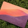 Printed wood card with an orange and purple sunset design