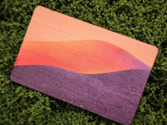 Printed wood card with an orange and purple sunset design